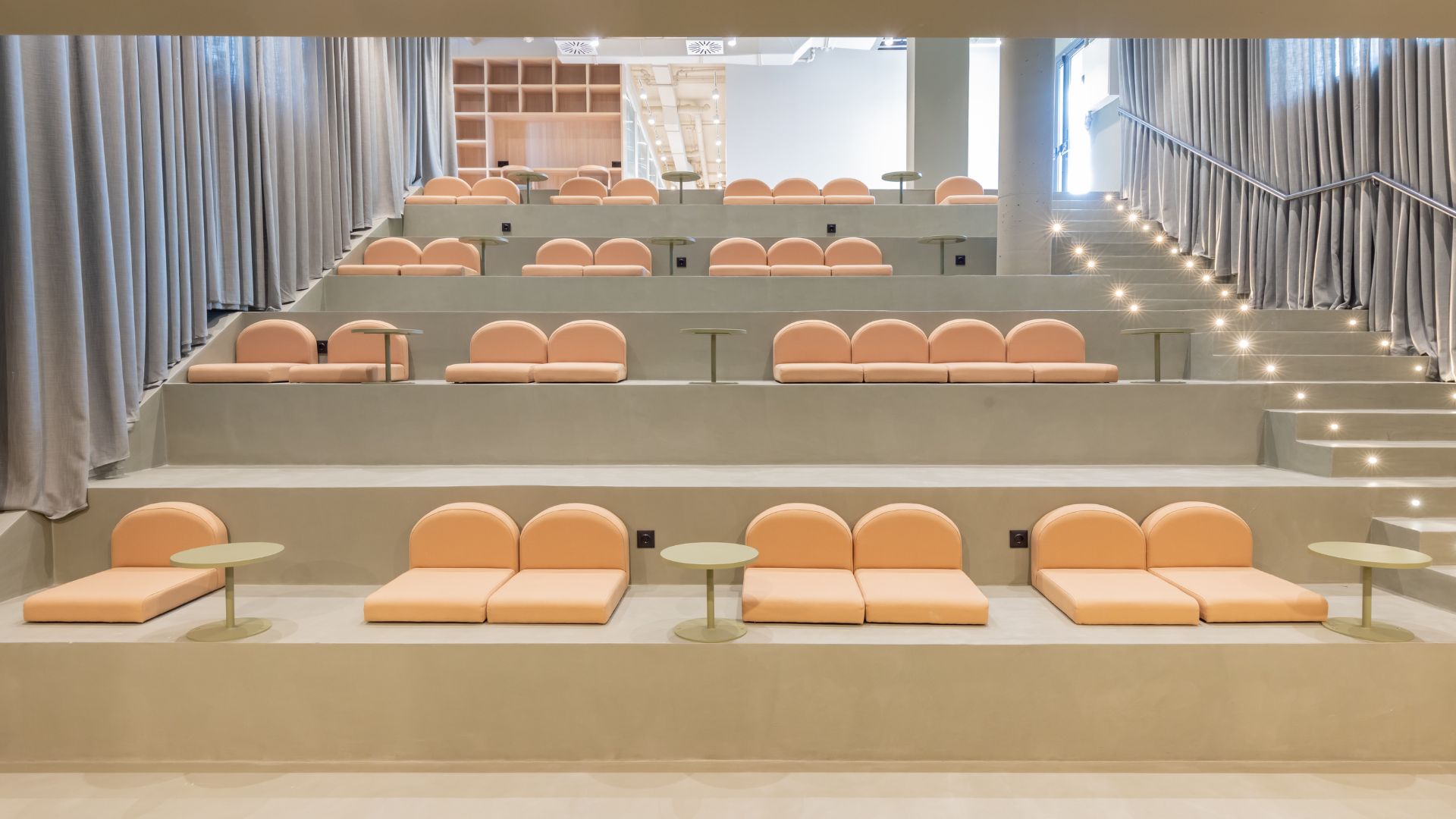 Sala tipo auditorio en la residencia universitaria de Cantoblanco, con asientos escalonados y diseño moderno.