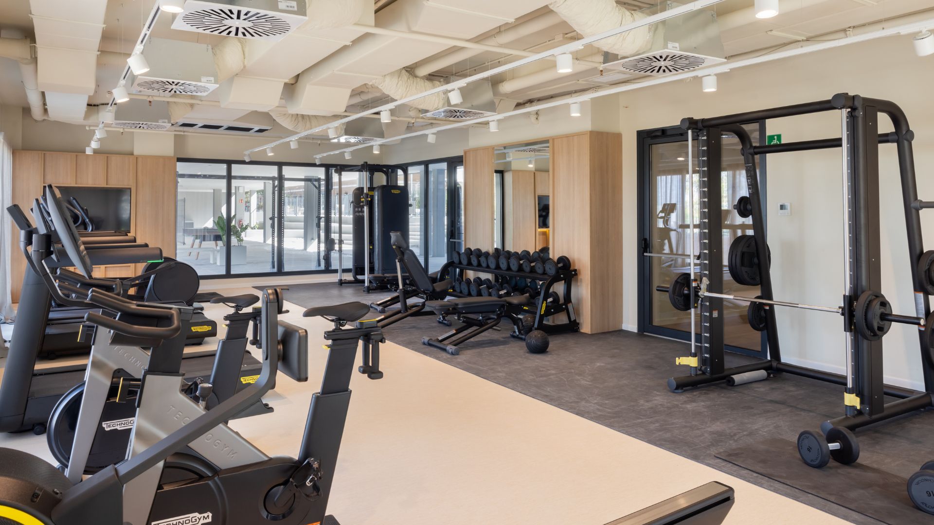 Gimnasio de la residencia universitaria de Cantoblanco, con zona de pesas y equipamiento profesional.