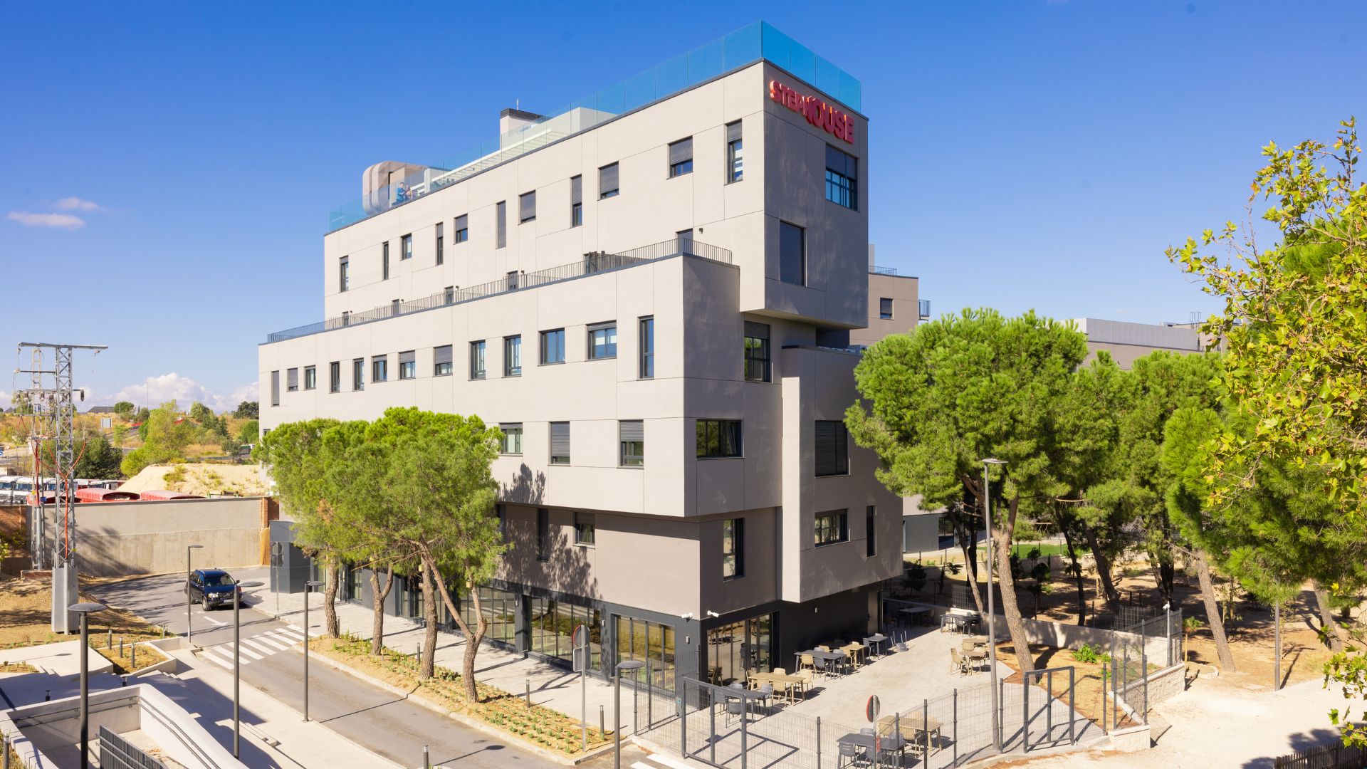 Vista exterior de la residencia universitaria en Cantoblanco, rodeada de zonas verdes y con terrazas al aire libre.