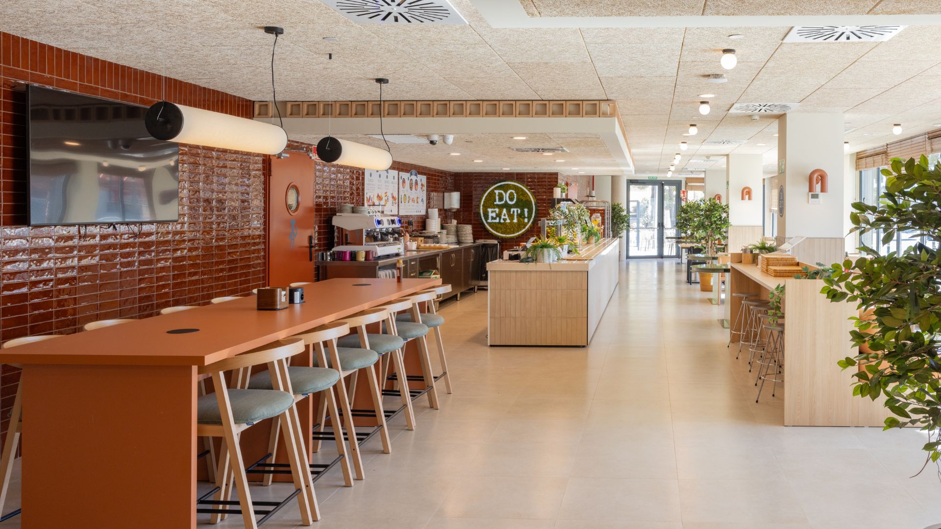 Zona de restauración y comedor común en la residencia universitaria de Cantoblanco, con mesas altas y ambiente moderno.