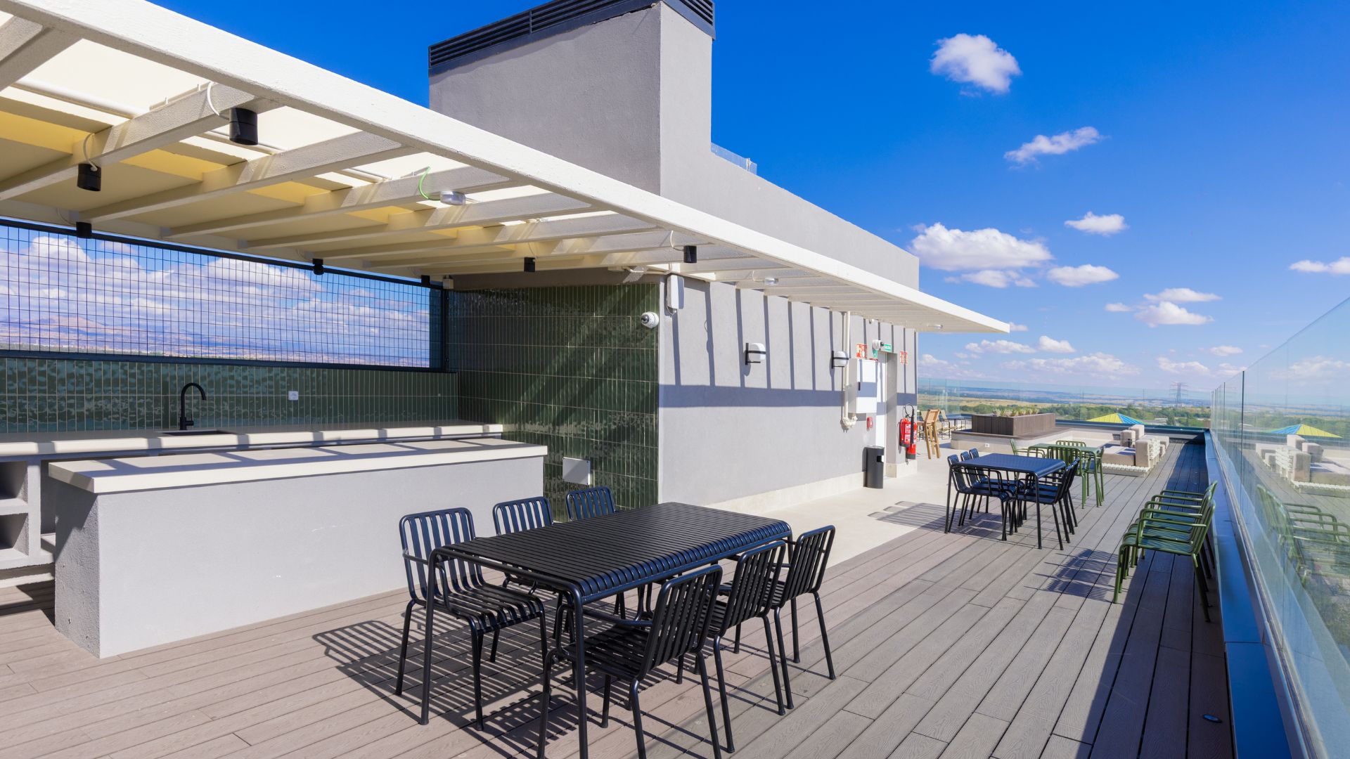 Terraza en la azotea de la residencia universitaria en Cantoblanco, con mesas, vistas abiertas y zona de descanso exterior.