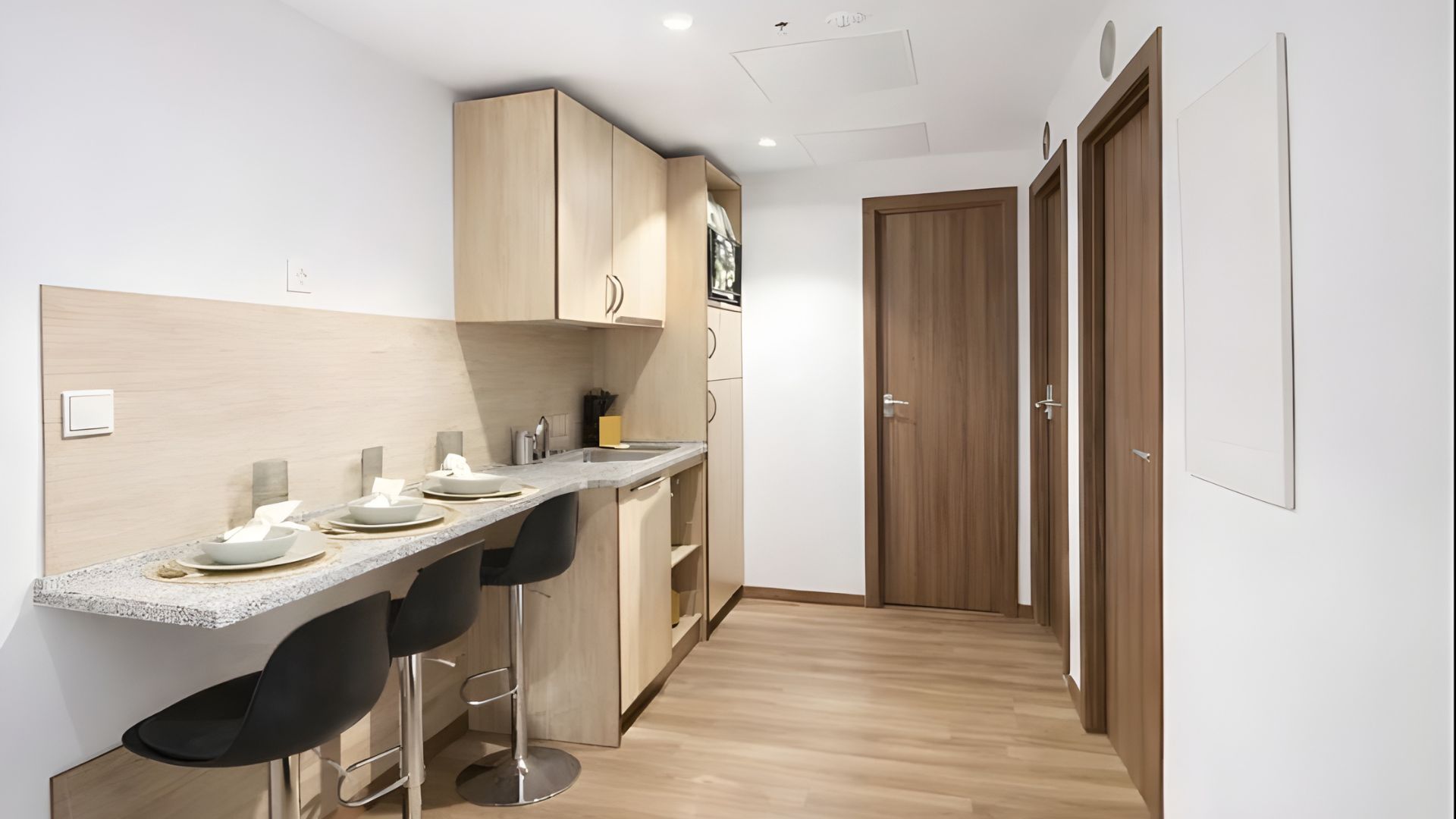 Cocina equipada con encimera, electrodomésticos y almacenamiento en estudio para estudiantes en Málaga.