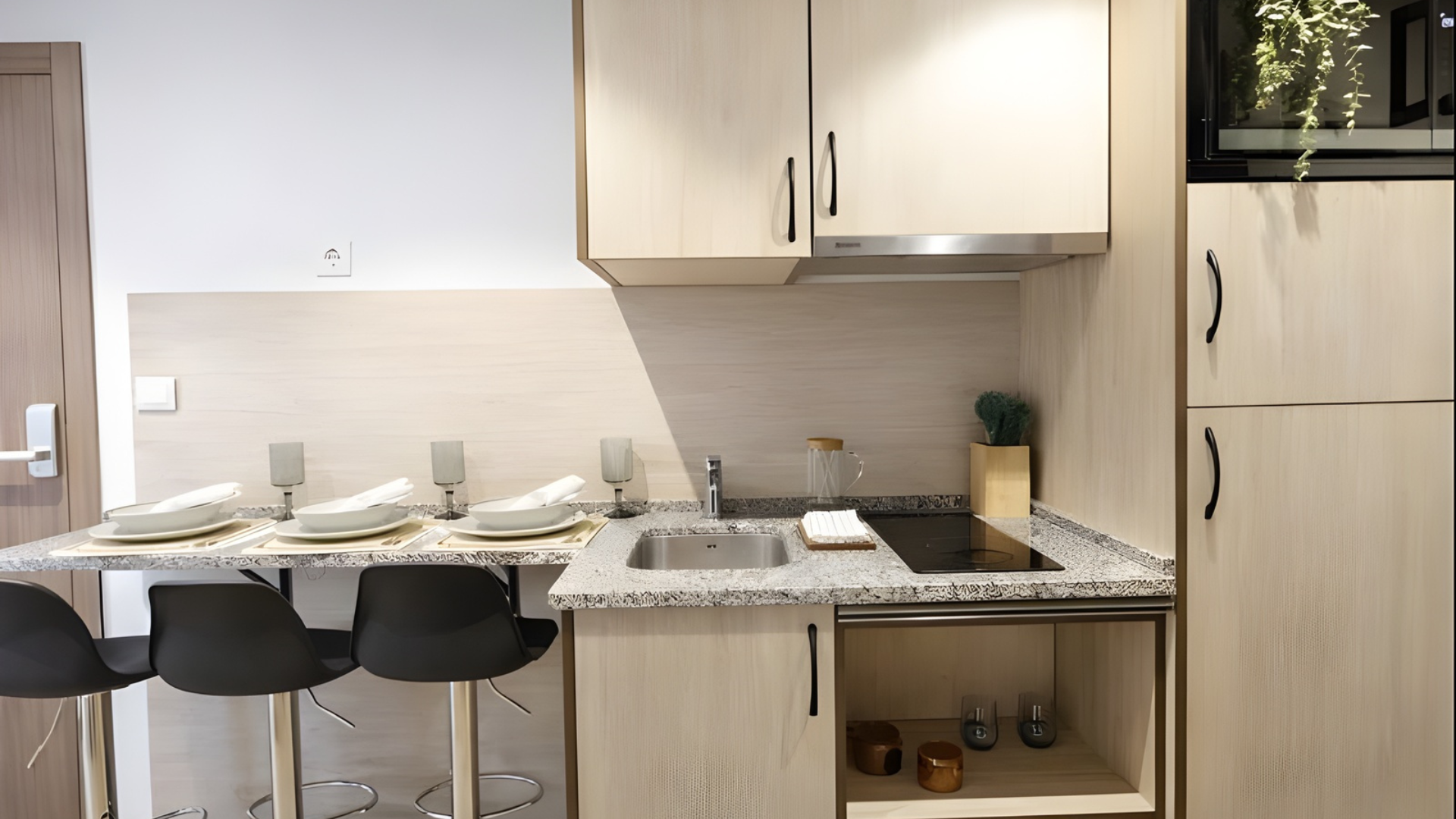 Cocina abierta con zona de comedor en estudio para estudiantes en Málaga.