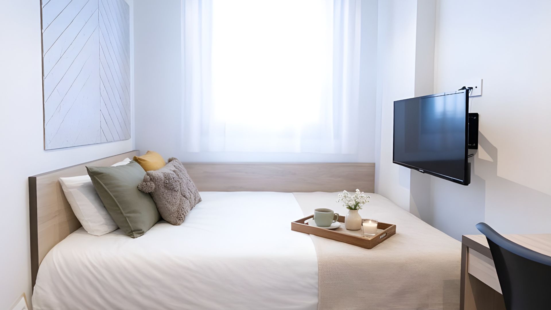 Dormitorio con zona de descanso y escritorio en estudio para estudiantes en Málaga.