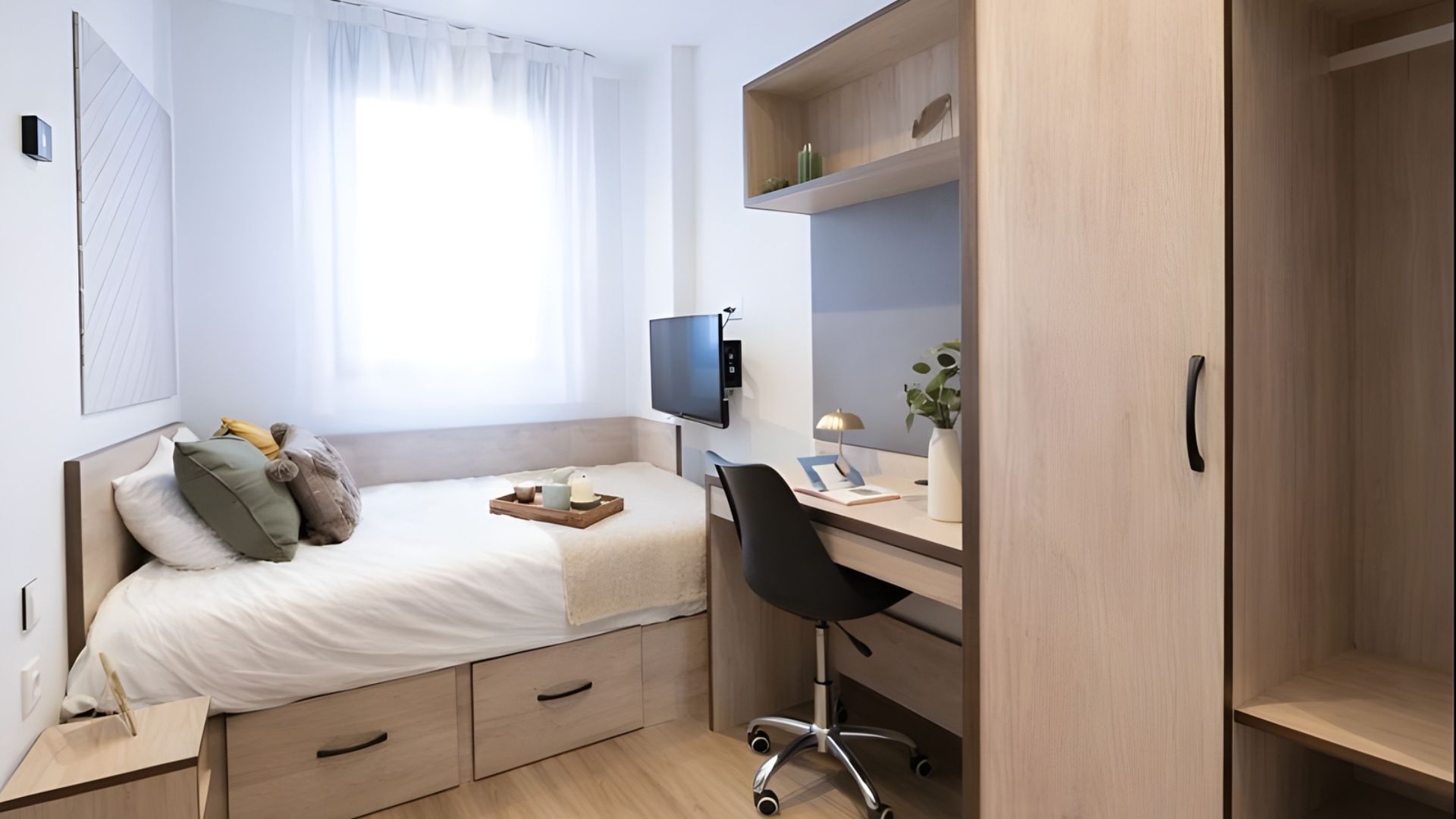 Dormitorio con zona de descanso y escritorio en estudio para estudiantes en Málaga.