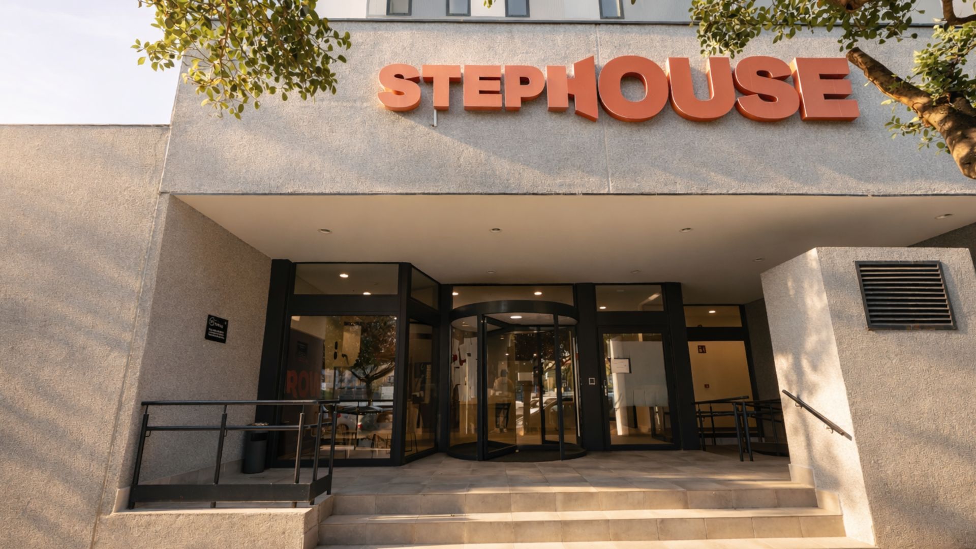 Entrada exterior de la residencia de estudiantes en Málaga con acceso principal y fachada moderna.