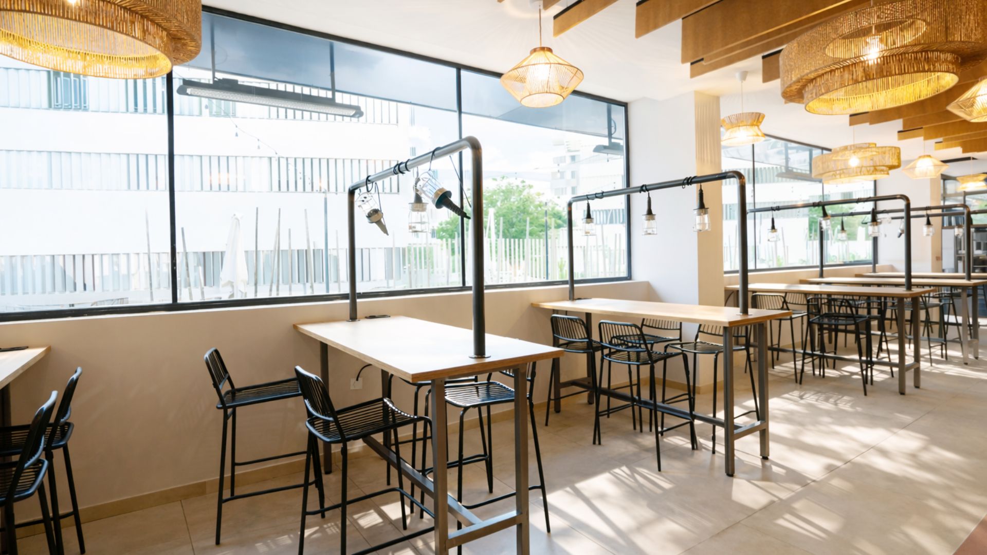 Espacio común de residencia de estudiantes en Sevilla con mesas altas y ambiente social