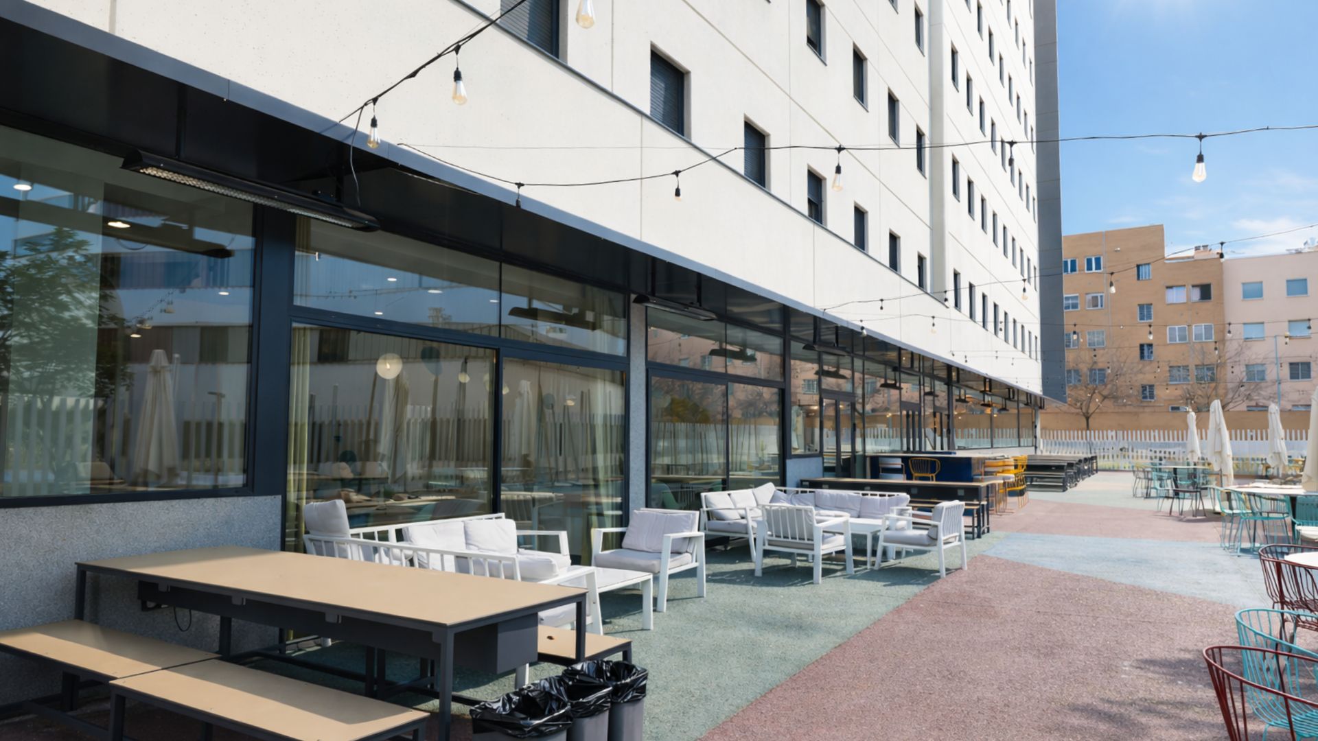 Zona exterior de residencia de estudiantes en Sevilla con espacios para socializar