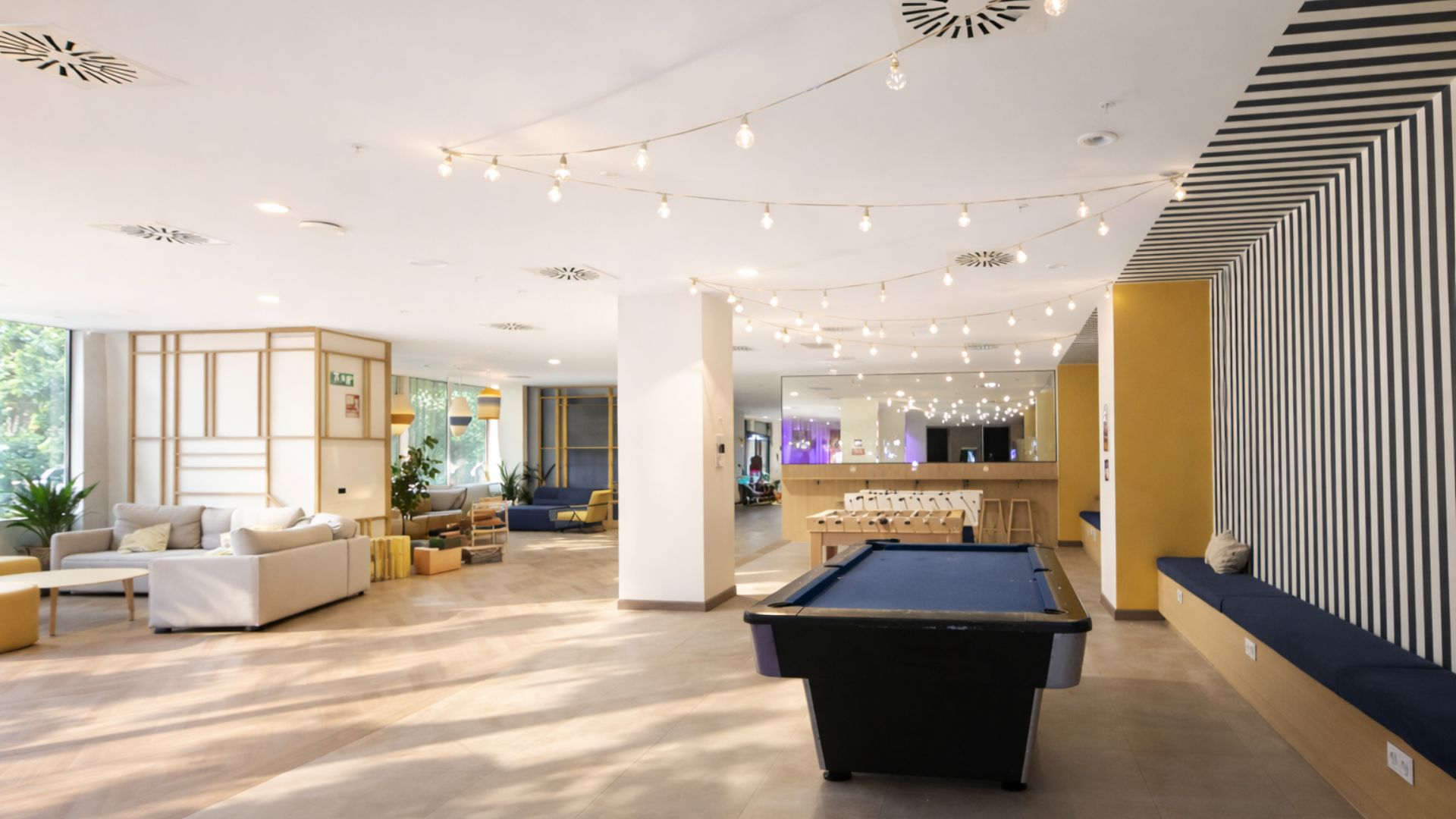 Gran zona común de residencia universitaria en Sevilla para ocio y convivencia