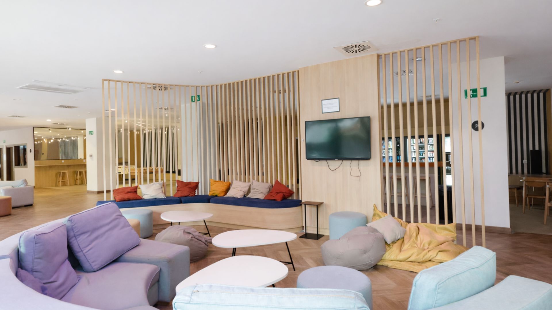 Salón común en residencia universitaria de Sevilla con sofás y zonas de descanso