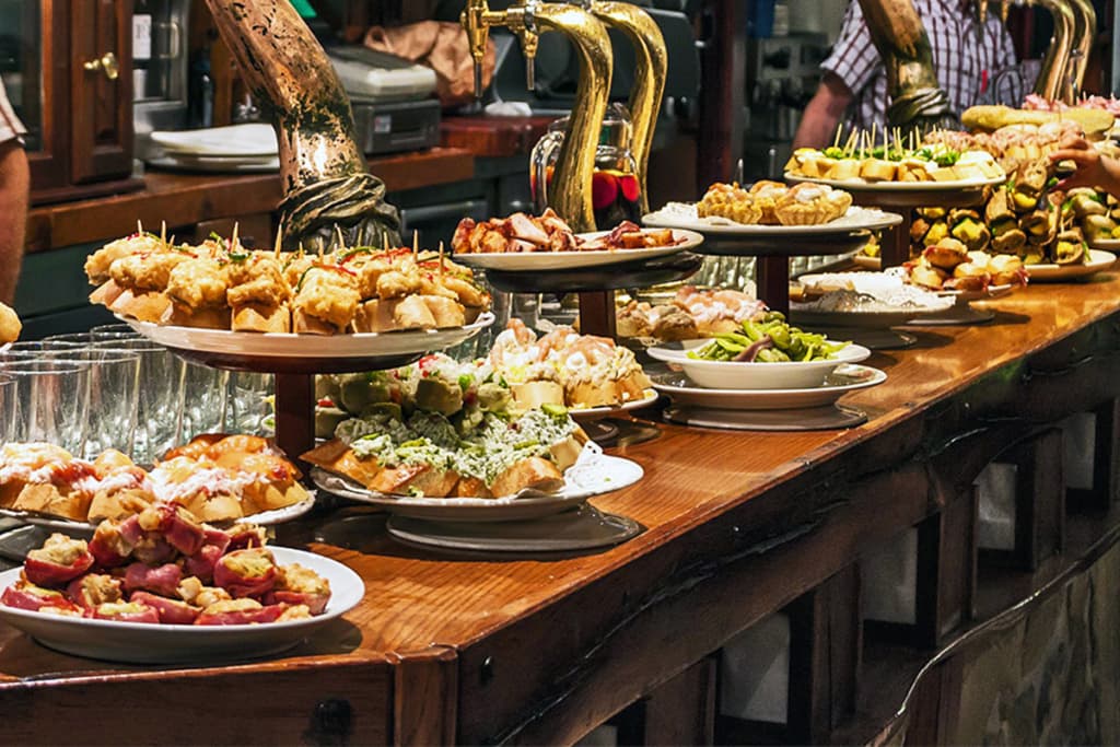 pintxopote con diferentes pintxos en barra de bar vasco