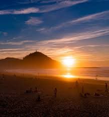 estudantes a apreciar o pôr-do-sol na praia de Zurriola