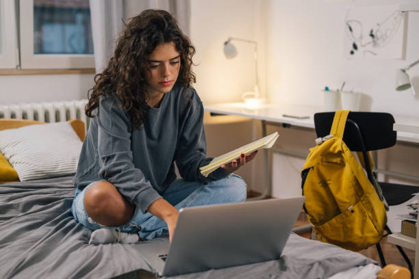 Estudante a trabalhar com um portátil no quarto ou num espaço de coworking
